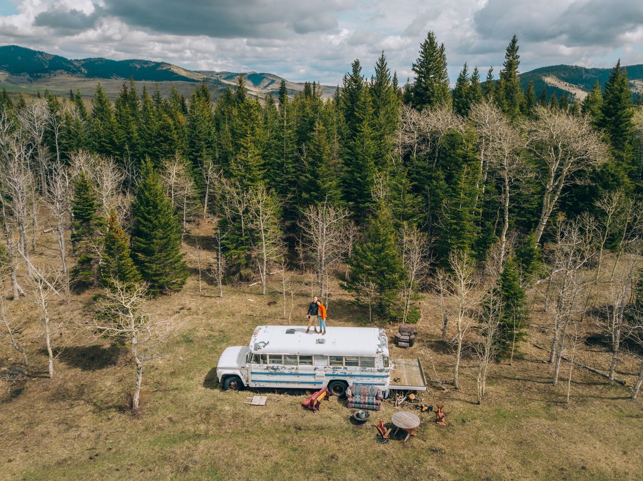 Aerial view of a camper bus and people in Alberta Beach forest, Canada.